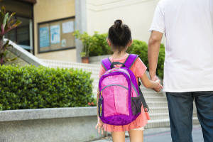 a father walking daughter to school