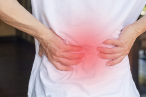 woman expresses back pain due to degenerative disc disease